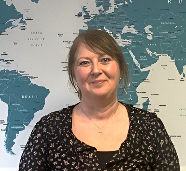 Rachel’s profile photo, standing in front of the office world map.