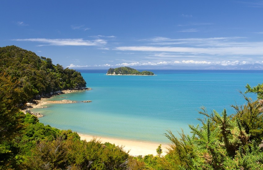 Calm beach in Abel Tasman National Park, South Island, New Zealand, with light blue waters