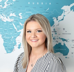 Profile picture of Fearne standing in front of an office world map.